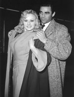 Steve Cochran helps Sabrina with her coat